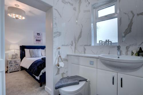 Baño blanco con lavabo y aseo en Norfolk Holiday Cottage 4-Bed Luxury Dog friendly en Heacham