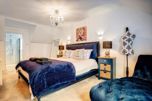 a bedroom with a large bed and a chair at Norfolk Luxe Beach House Sleeps 8 Dog friendly in Heacham