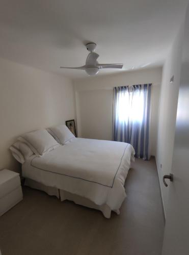 een witte slaapkamer met een bed en een raam bij Precioso apartamento de 2 habitaciones recién reformado en Benidorm in Benidorm