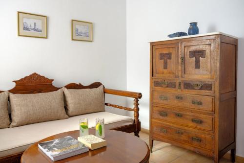 a living room with a bed and a wooden dresser at Nikos Villas in Oia