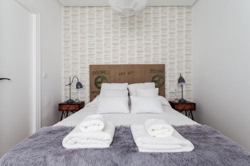 sypialnia z łóżkiem i dwoma ręcznikami na nim w obiekcie Green-Apartments San Francisco w Sewilli