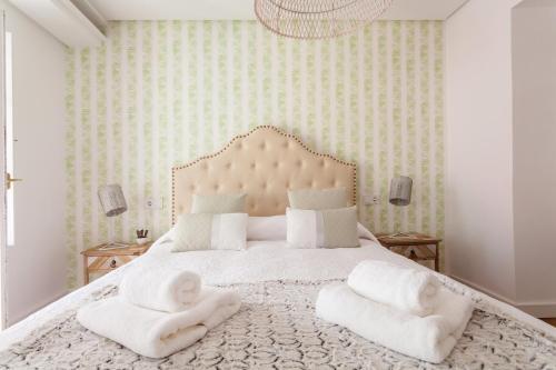 a bedroom with a large bed with white towels on it at Green-Apartments San Francisco in Seville