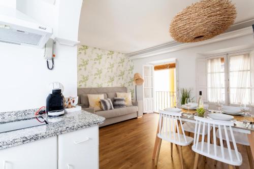 a white kitchen and living room with a couch at Green-Apartments San Francisco in Seville