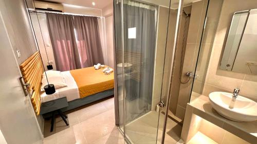 a bathroom with a bed and a sink and a shower at Atlantis Hotel in Agios Nikolaos