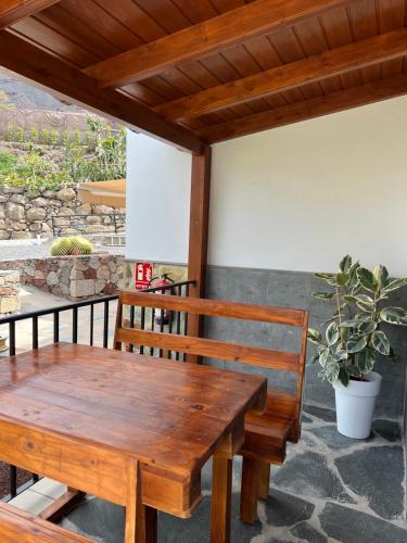 a wooden table and benches on a patio at Casa rural con baño adaptado y piscina en Mogán in Mogán