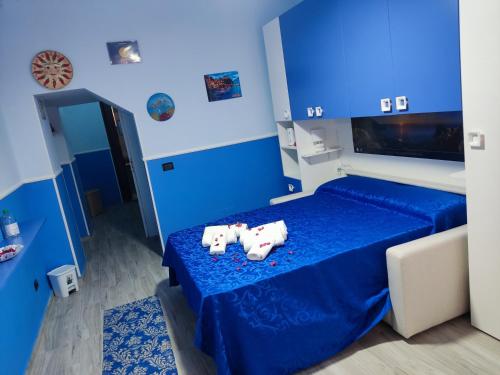 a blue bedroom with two white towels on a bed at Da zio Michele in Scilla