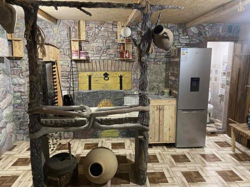 a kitchen with a refrigerator and a stone wall at Portak GuestHouse Near SEVAN Lake in Sevan