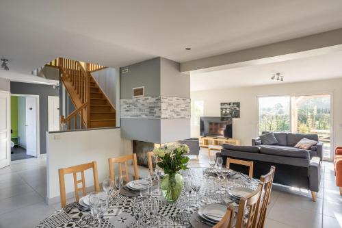 une salle à manger et un salon avec une table et des chaises dans l'établissement La Baie Blanche - Maison contemporaine à Saint-Cast-Le-Guildo, à Saint-Cast-le-Guildo