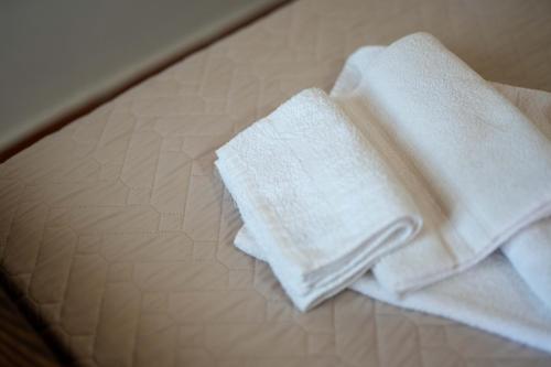dwa białe ręczniki siedzące na szklanym stole w obiekcie B&B Aria Antica w mieście Verbicaro
