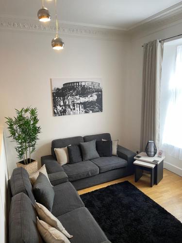 a living room with a gray couch and a table at Heart of George Street 2 in Oban