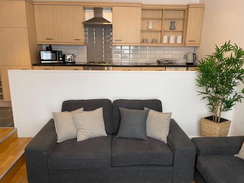a living room with a couch in front of a kitchen at Heart of George Street 2 in Oban