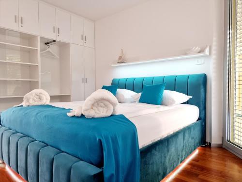 Una cama azul con toallas en una habitación en VIP Apartment Portorož, en Portorož