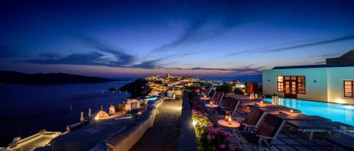 un hotel con vista sull'acqua di notte di Nikos Villas a Oia