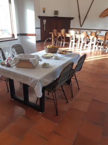 a table with a white table cloth and chairs at Casa do Coura in Caminha