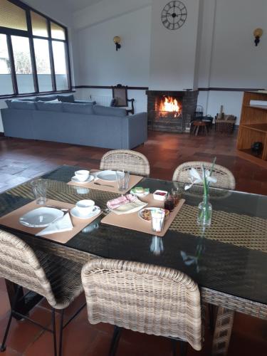 a dining room with a table and chairs and a fireplace at Casa do Coura in Caminha