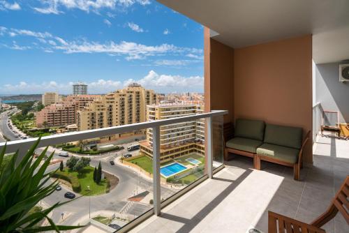 a balcony with a couch and a view of a city at Casa Keronen - Elite Residence in Portimão