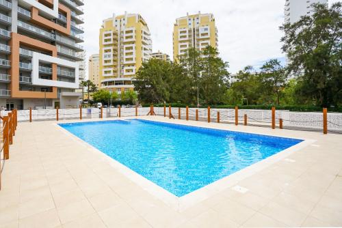 a swimming pool in a building with buildings in the background at Casa Keronen - Elite Residence in Portimão