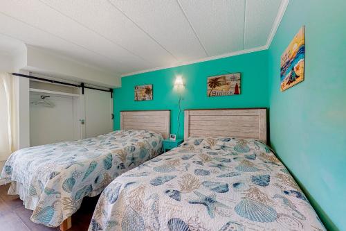 Pintail Point Condos في آوشين سيتي: سريرين في غرفة بجدران خضراء
