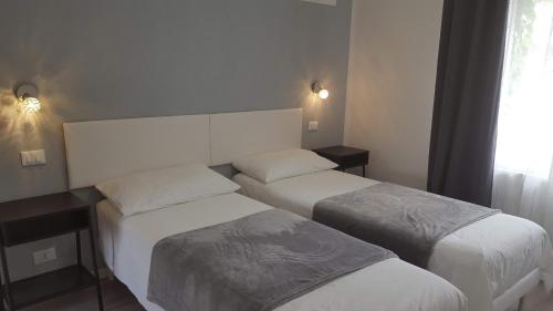 a hotel room with two beds and a window at Altebas in Nogaredo di Prato