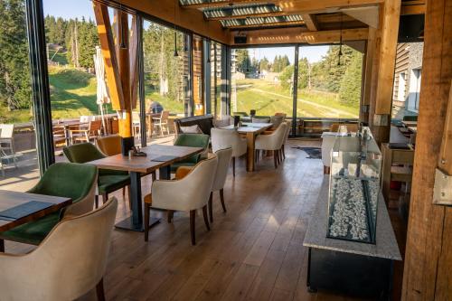 a restaurant with tables and chairs and large windows at Gorski Hotel & Spa in Kopaonik