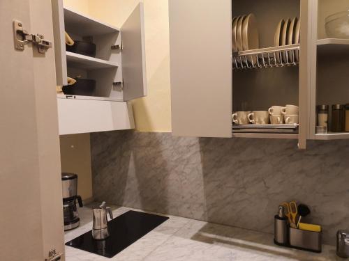 uma cozinha com armários brancos e uma bancada em RF Duomo suites em Florença