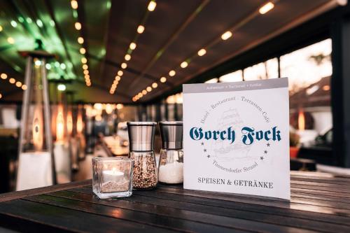 a sign sitting on top of a table with glasses at Hotel Gorch Fock in Timmendorfer Strand