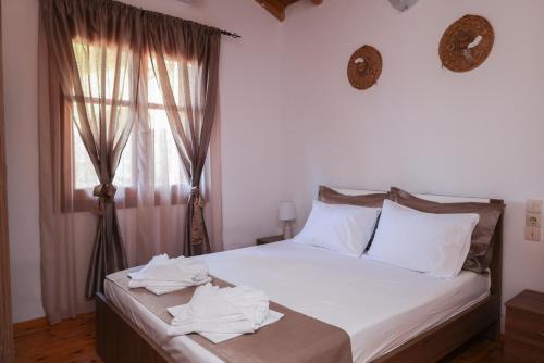a bedroom with a bed with white sheets and a window at F & B Summer Collection- Skiathos -Maistrali in Skiathos Town