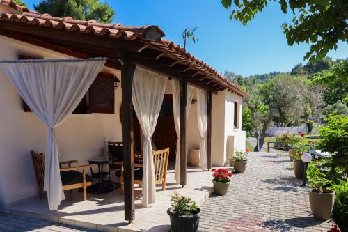 a patio with white curtains on a house at F & B Summer Collection- Skiathos -Maistrali in Skiathos Town