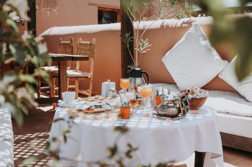 uma mesa branca com comida e bebidas em Dar Nour el Houda em Marrakech