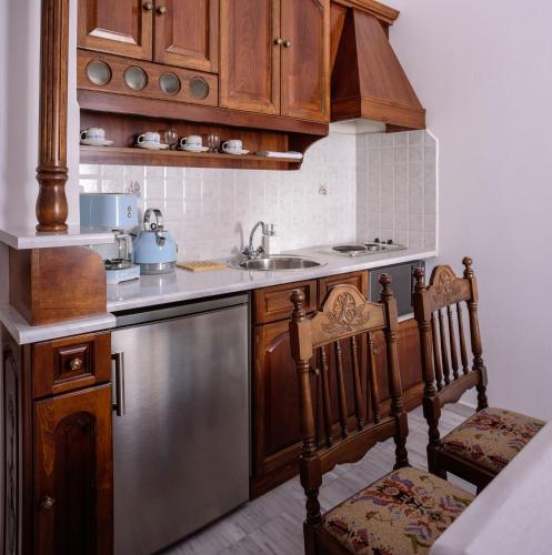 a kitchen with wooden cabinets and a stainless steel dishwasher at Nikos Villas in Oia