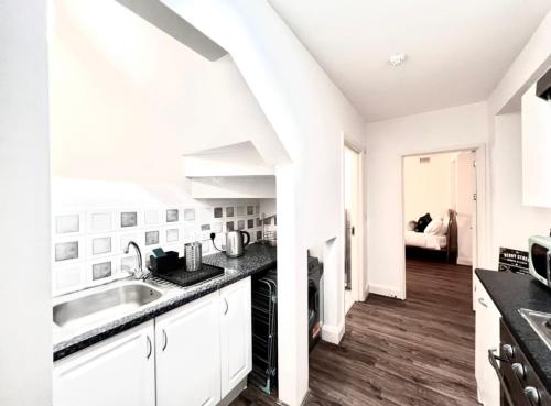 a white kitchen with a sink and a stove at BEST LOCATION Central London 2 Bedrooms Sleeps up to 4 or 5 Middle of all attractions in London