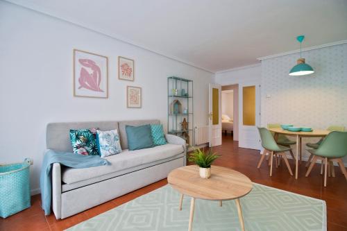 a living room with a couch and a table at Abba Comillas Apartments in Comillas