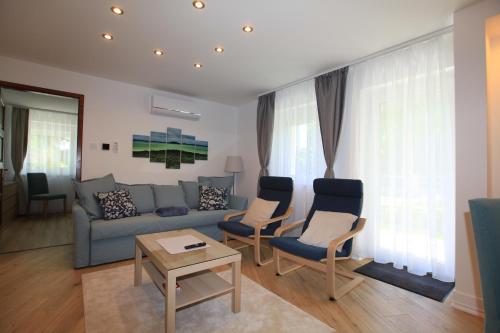 a living room with a blue couch and chairs at Paskal-Lux Apartments with Free Parking and AC in Budapest