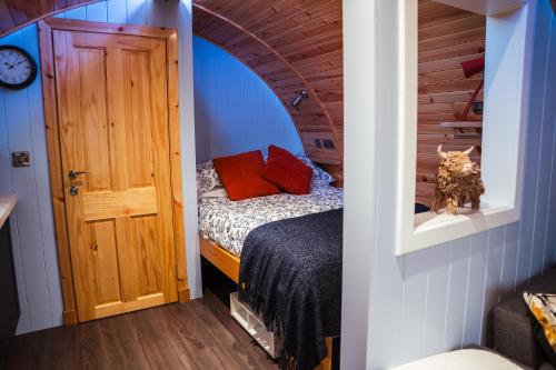 a bedroom with a bed in a room with a door at Fulshaw Mill Holidays in Stewarton