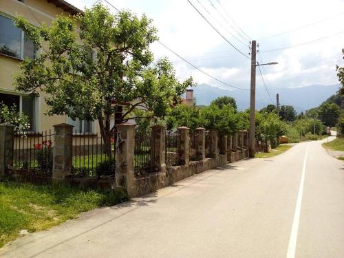 uma cerca ao lado de uma estrada ao lado de uma casa em Къща за гости Край реките em Apriltsi