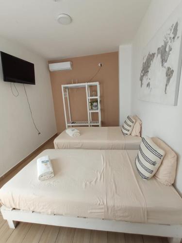 a hotel room with two beds and a tv at La Maja Suites in Villahermosa