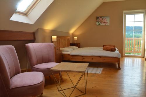 a bedroom with two beds and a table and chairs at Dom w Beskidach in Stryszawa