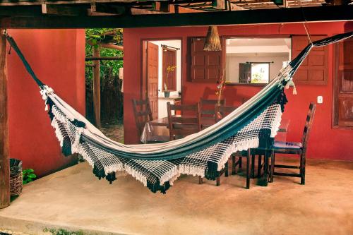 een hangmat in een huis met een eetkamer bij Pousada Do Guga in Caraíva
