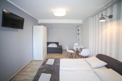 a bedroom with a bed and a table with chairs at Oaza Leba - Idealny dla rodzin z dziecmi - FIRST MINUTE SEZON 2026!!! in Łeba