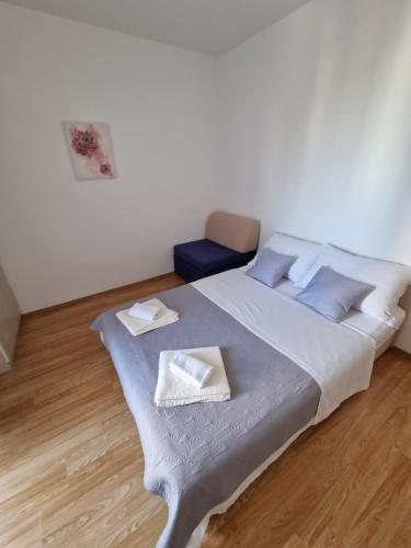een slaapkamer met een groot bed met blauwe kussens bij Apartments Lili in Biograd na Moru