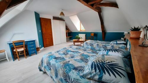 - une chambre avec 2 lits avec des draps bleus et blancs dans l'établissement La Ménagerie, à Maigné