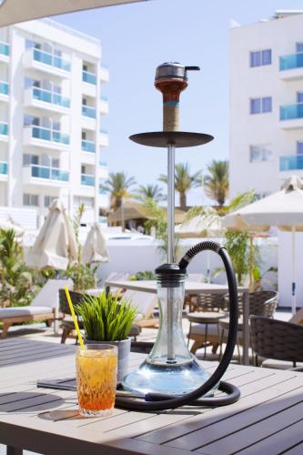 a table with a blender and a drink on a table at Kapetanios Bay Hotel Protaras in Protaras