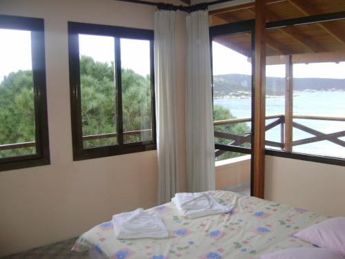 a bedroom with a bed and windows with a view at Teras Motel in Foça