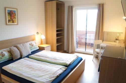 a hotel room with a bed and a window at Sauschneidhof - Radstadt in Radstadt