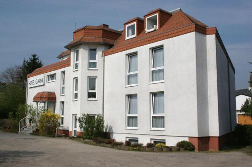 ein großes weißes Gebäude mit rotem Dach in der Unterkunft Hotel Garni in Rosbach vor der Höhe