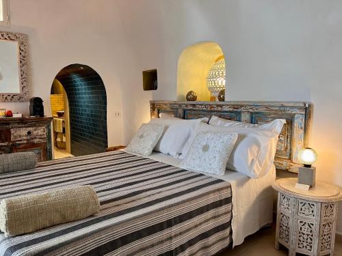 1 dormitorio con 1 cama grande con almohadas blancas en Il Saraceno B&B, en Carovigno