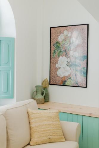a living room with a couch and a painting on the wall at La Casa Degli Archi in Kos