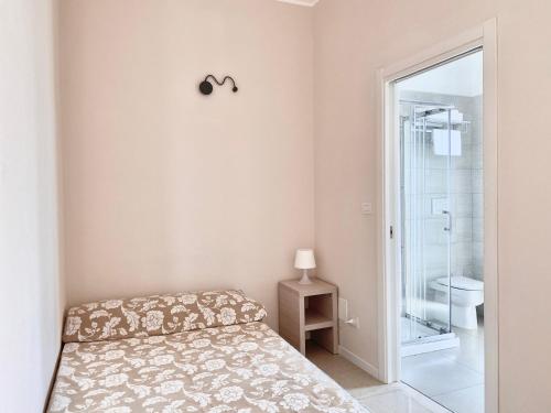 a small bedroom with a bed and a bathroom at Santa Barbara hotel & apartments in Bellaria-Igea Marina