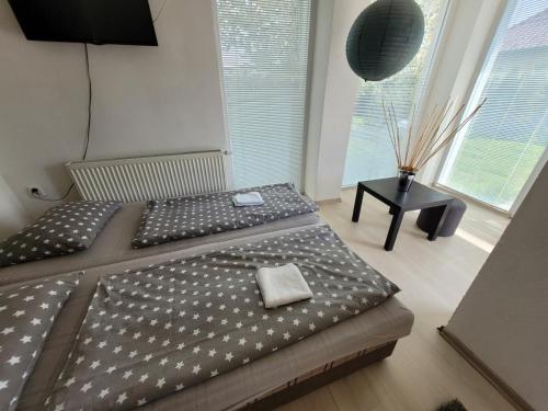 a bedroom with a bed with a black and white comforter at Apartman La Martina in Vráble