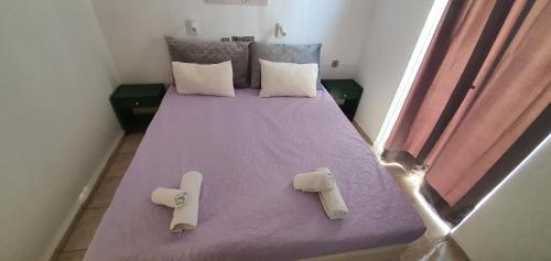 a bedroom with a purple bed with two pillows at Stella Apartments in Kokkíni Khánion